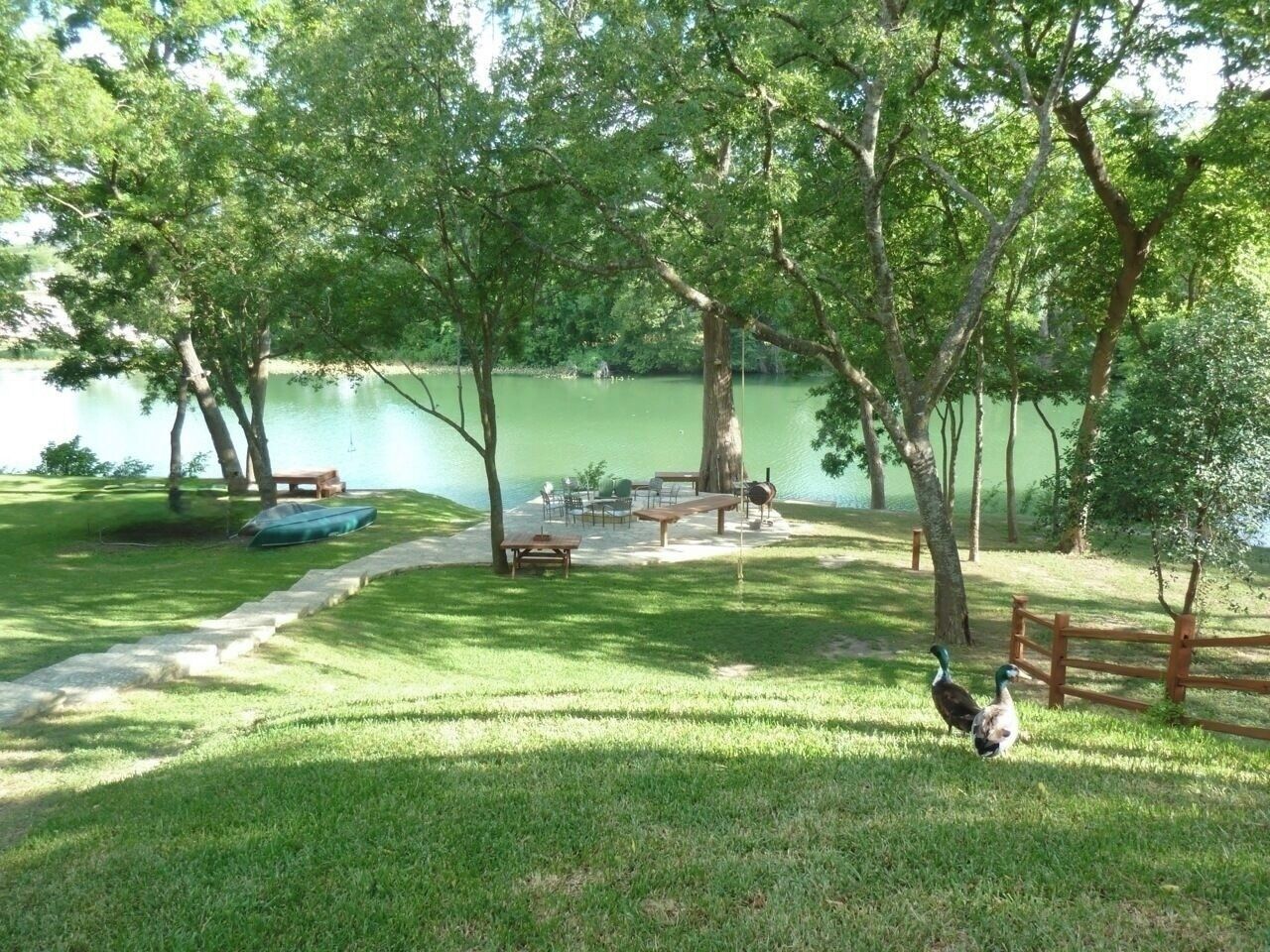 Un parc au bord du lac, équipé de tables de pique-nique, d’un canoë et où l’on peut observer des canards.