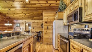 A wooden cabin-style kitchen with a wooden ceiling, stainless steel appliances, and a built-in microwave. - 4 bedroom 4 bathroom sleeps 14 outdoor pool access great mountain views and free internet access (Sevierville)