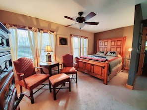 Cozy retreat with a traditional bed, nightstand, and chair, perfect for a restful stay.