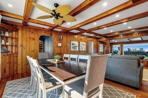 A dining area with a wooden table, chairs, and a ceiling fan.