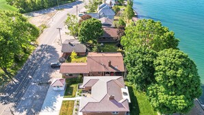 Vue aérienne d’un quartier résidentiel avec des maisons, une route et une étendue d’eau.