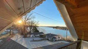 Une vue depuis un balcon en bois donnant sur un quartier résidentiel avec des maisons et un lac.