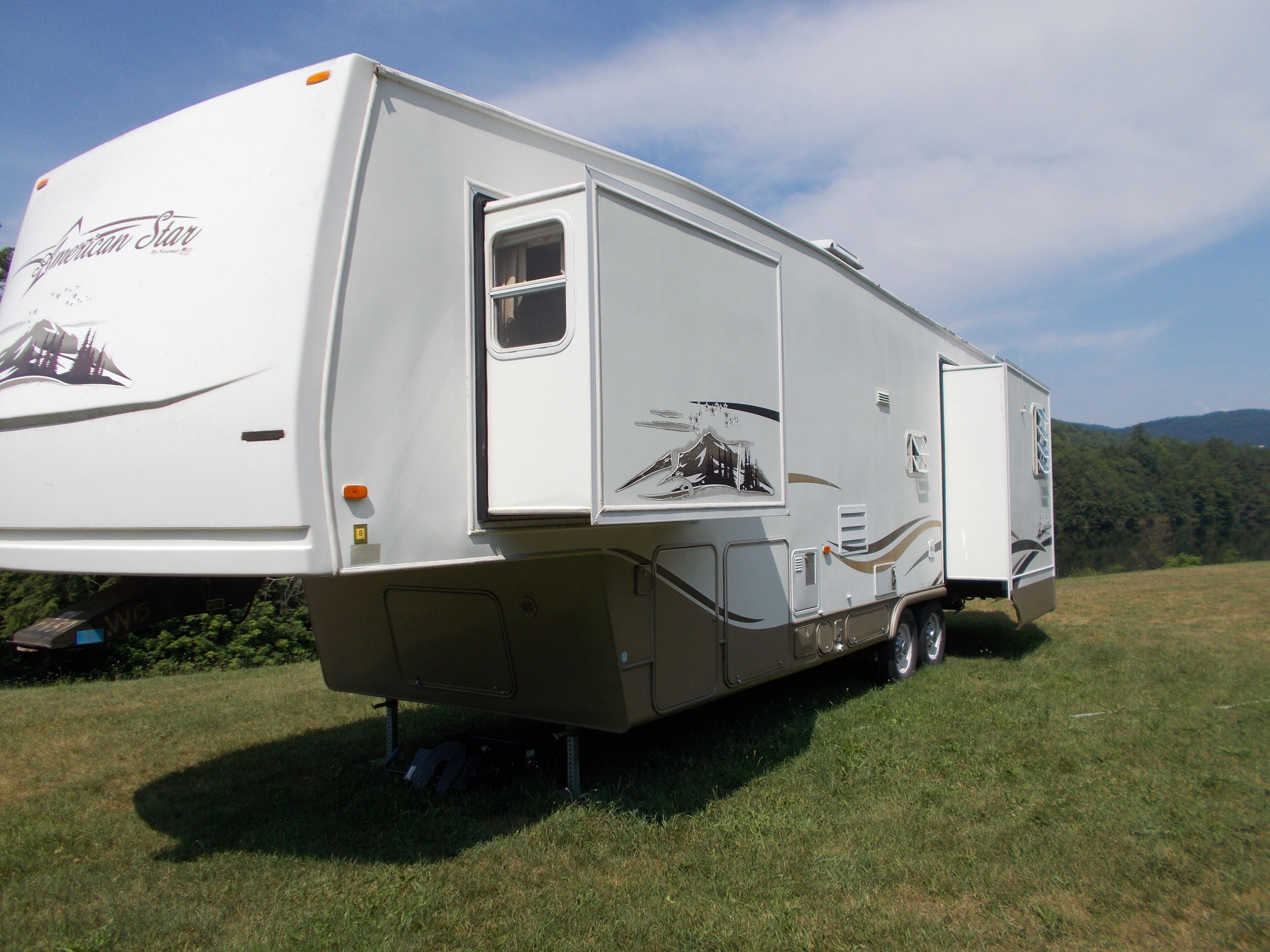 A stationary RV with a logo, a small window, and a door.