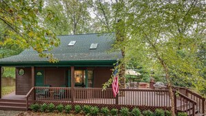 A lodge with a porch, outdoor seating, and a flag.
