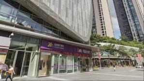 A modern building with a prominent 'K' logo, surrounded by high-rise buildings. - Tata Hotel Apartment Shenzhen (Shenzhen)