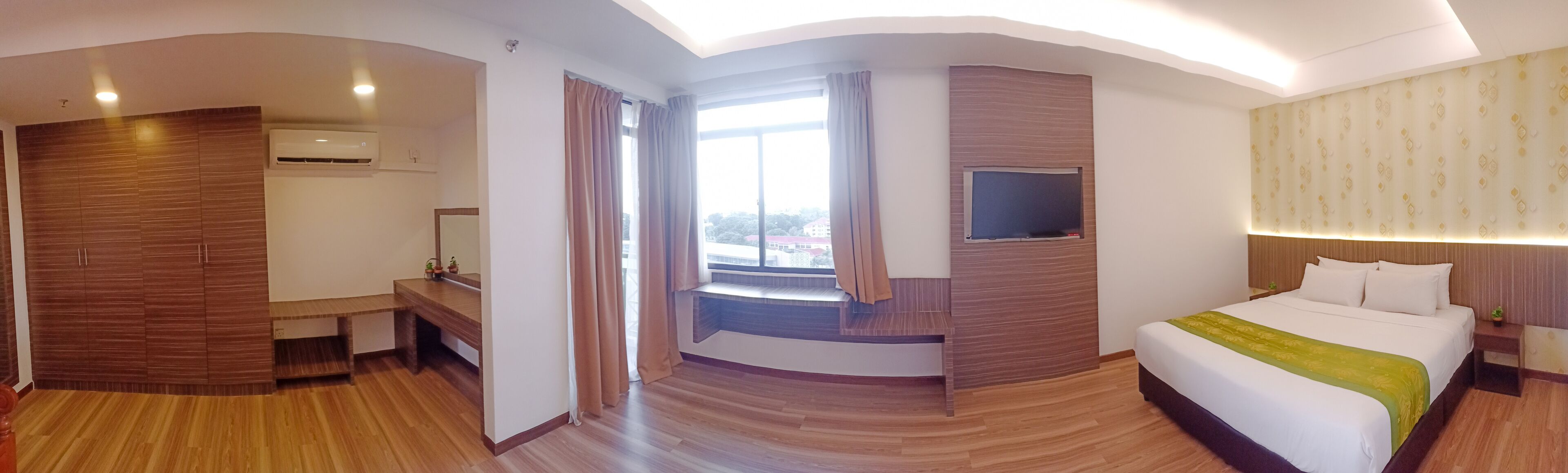 A modern hotel room with a large bed, a desk, and a TV.
