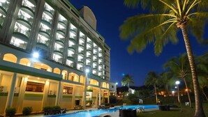 A hotel with multiple balconies, a swimming pool, and palm trees. - De Greenish Village Langkawi (Langkawi)
