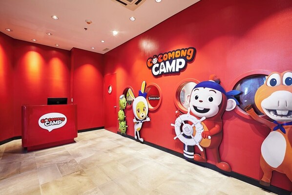 A red wall with the text "Cocomong CAMP" and cartoon characters. - Kensington Hotel Saipan (Saipan)