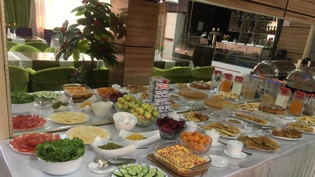 Een buffet met diverse gerechten, waaronder salades, fruit en desserts.