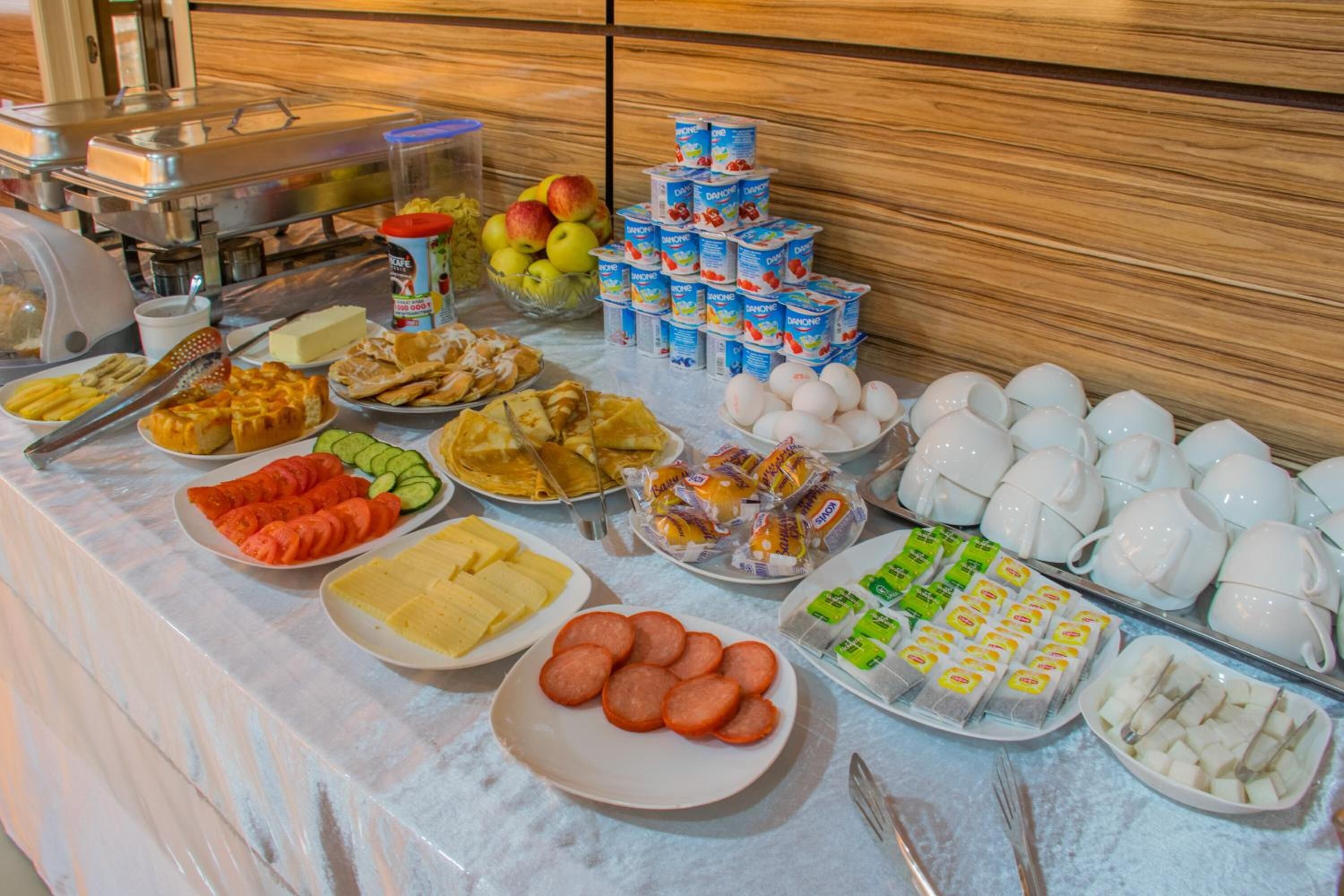 Un bufé con una variedad de alimentos, incluyendo frutas, quesos, carnes y productos lácteos.