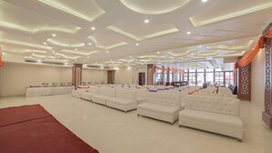 Un amplio salón con asientos escalonados, un escenario e iluminación decorativa.