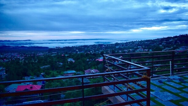 Vista desde un balcón sobre un pueblo con cielo despejado.