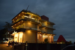 Vista frontal de la propiedad por la tarde o noche