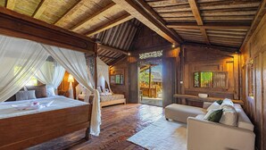 Una cabaña de madera con una cama, un sofá y una zona de comedor.