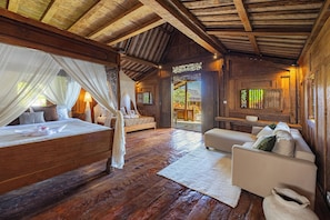 Una cabaña de madera con una cama, un sofá y una zona de comedor.