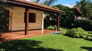 A single-story building with a tiled roof and a small porch. - Comfortable house (large balcony and garden), 70 meters from the beach with Wi-Fi.   (praia da lagoinha ubatuba)