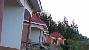 A building with a red roof and a paved pathway leading to the entrance.