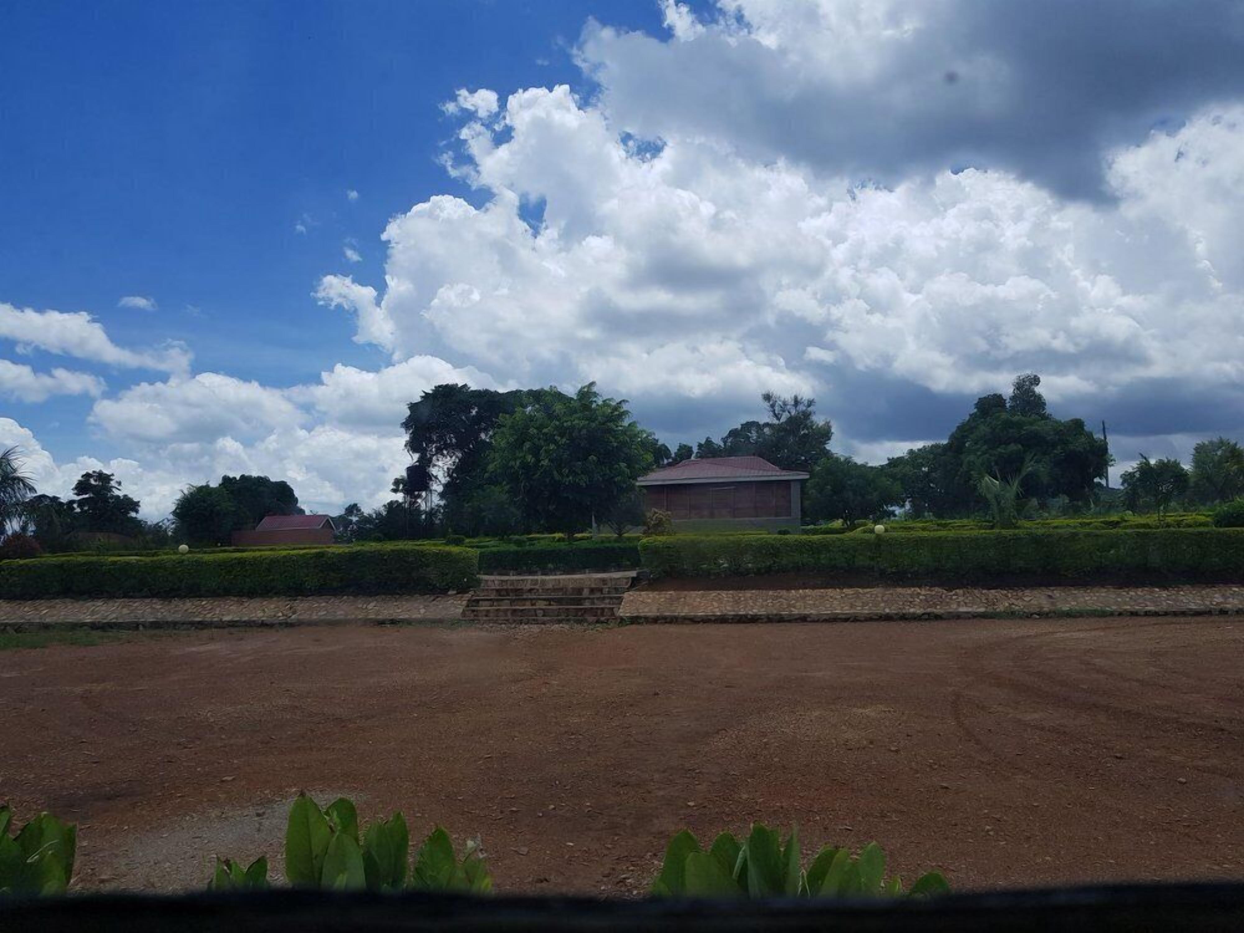 Um extenso campo aberto com um edifício ao fundo.