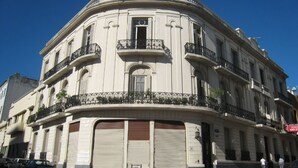 Un bâtiment historique doté d’une façade incurvée, de nombreux balcons et de grandes portes de garage.