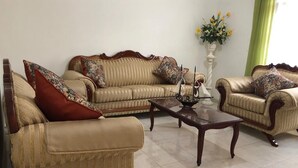 A living room with two sofas, a coffee table, and a vase with flowers on a pedestal. - HERMOSA CASA EN AJIJIC (San Antonio Tlayacapan)