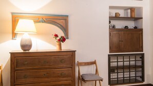 A wooden dresser with drawers, a lamp, and a vase with flowers. - Piazza Navona Charming Apartment (Roma)