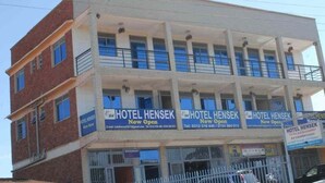 A multi-story hotel with 'HOTEL HENSEK' signage, balconies, and a restaurant sign. - Hotel Hensek (Kampala)