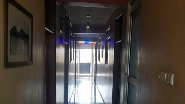 A long, narrow hallway with doors on both sides leading to rooms. - Hotel Hensek (Kampala)