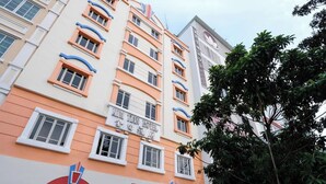 A multi-story hotel with a distinctive orange and white facade, featuring a prominent sign for the "XIN TEIN HOTEL". - Kim Tian Hotel Star (Singapore)
