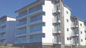 A multi-story building with balconies and a flat facade. - LUXURY APARTMENT PORTH, SLEEPS 4, SEA VIEWS OVERLOOKING WHIPSDERRY BEACH (Porth, Newquay)