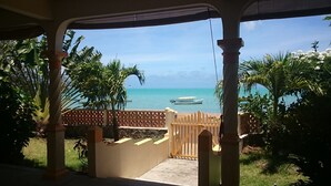 A covered outdoor area with a view of the ocean and a boat.