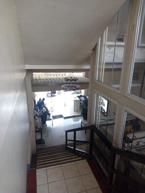 A staircase leading to a lower level with a view of a reception area and a dining space. - Ekonumi Rooms at Benrosi Plaza (Parañaque)