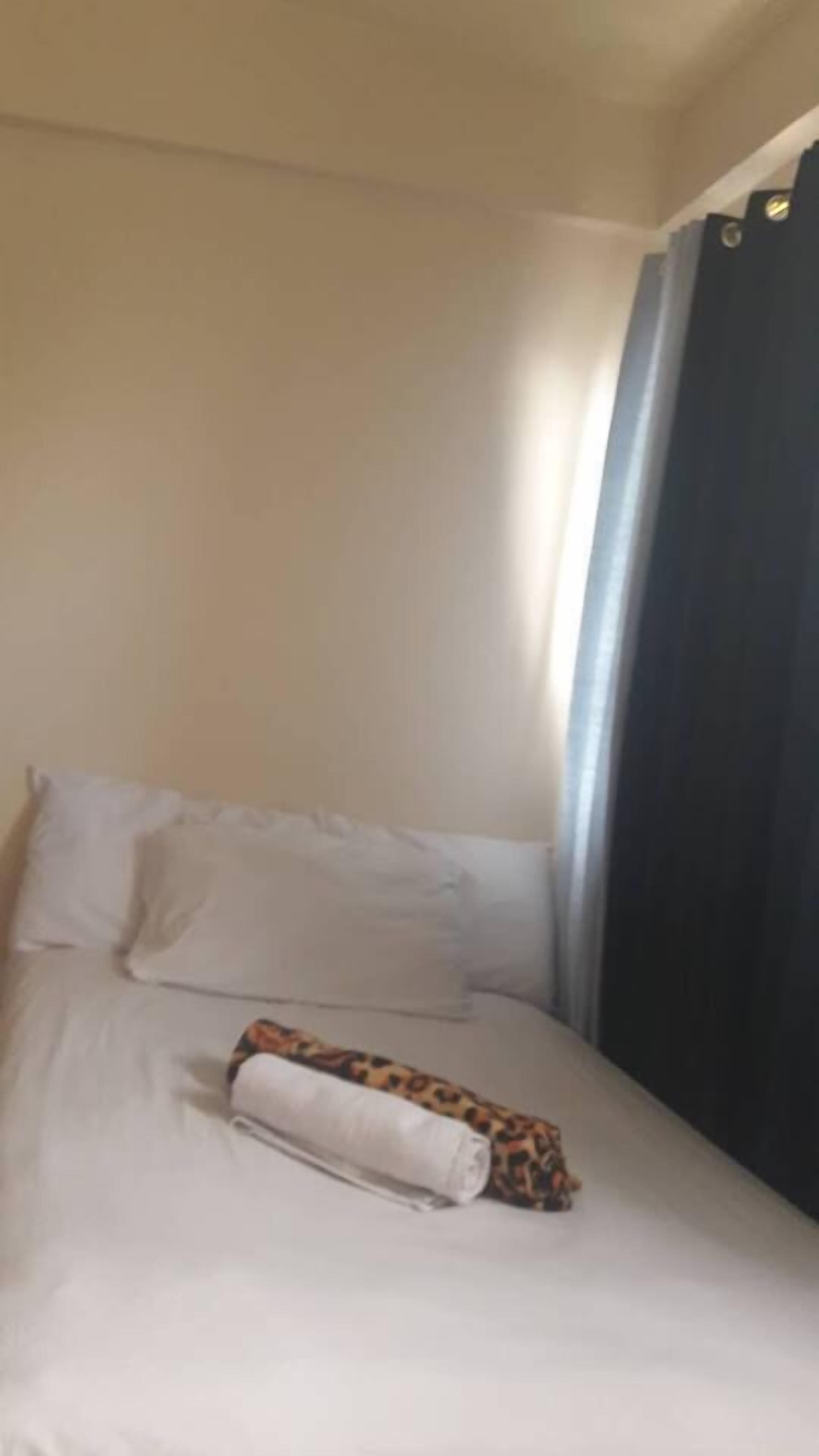 Une chambre d’hôtel avec un lit, des oreillers et une couverture.