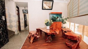 Ein Essbereich mit Holztisch und -stühlen, einem Aquarium und einem Blumentopf.