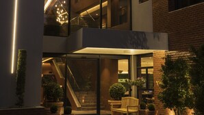 A modern building with a glass facade, multiple floors, and a central staircase.