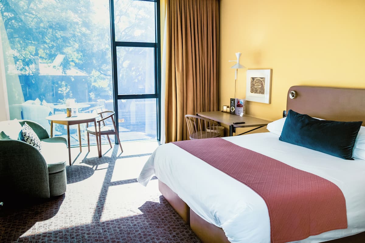 Une chambre d’hôtel avec un grand lit, un bureau, une chaise et un canapé.
