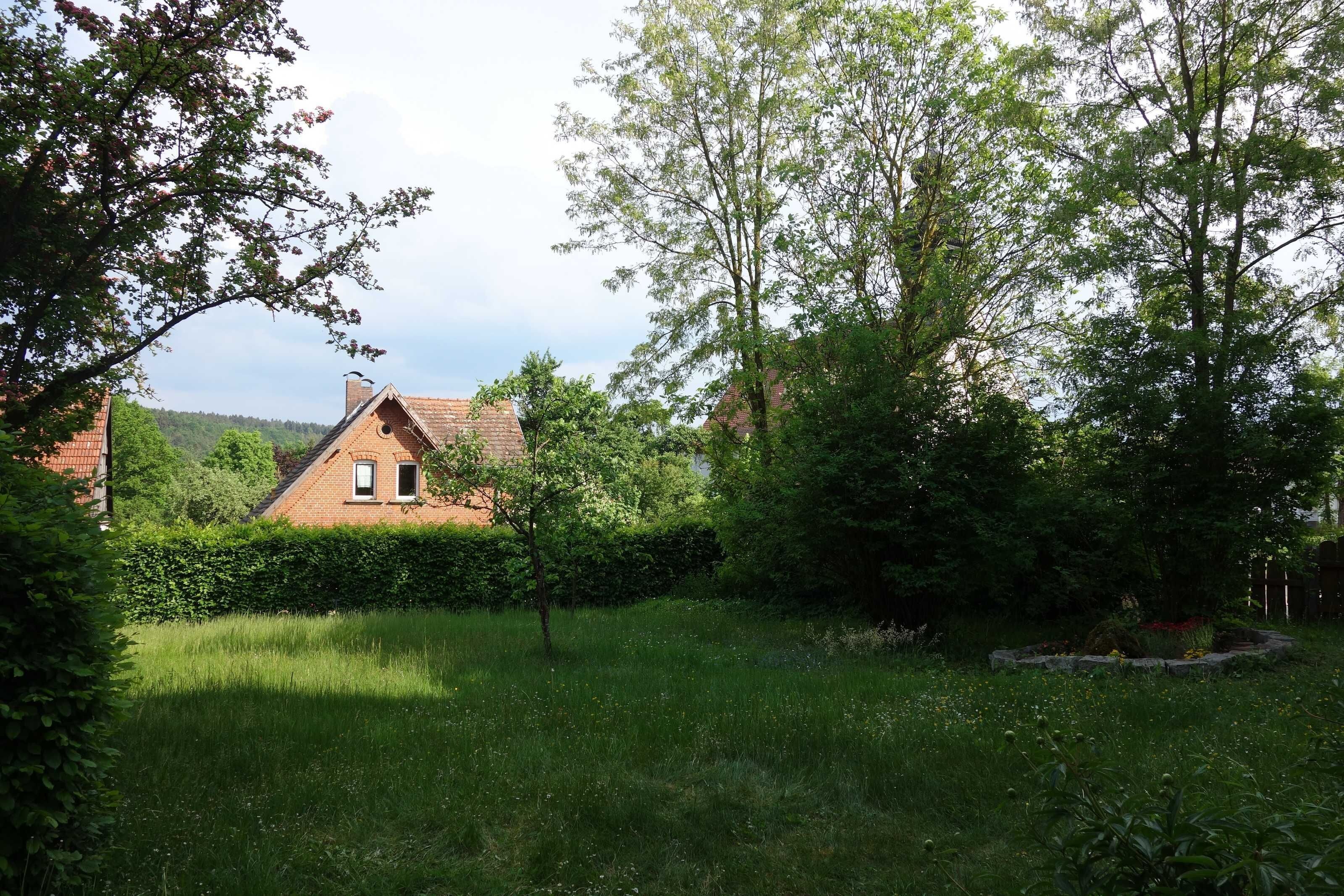 Une maison entourée d’une végétation luxuriante et dotée d’un jardin bien entretenu.