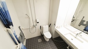 Un baño moderno con un lavamanos blanco, inodoro y zona de ducha.