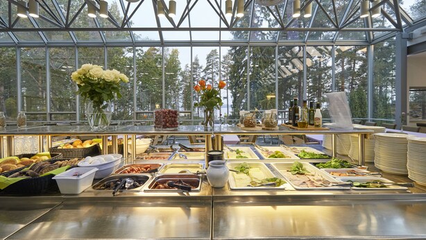 Un buffet proposant une variété de plats et une grande fenêtre donnant sur les arbres.