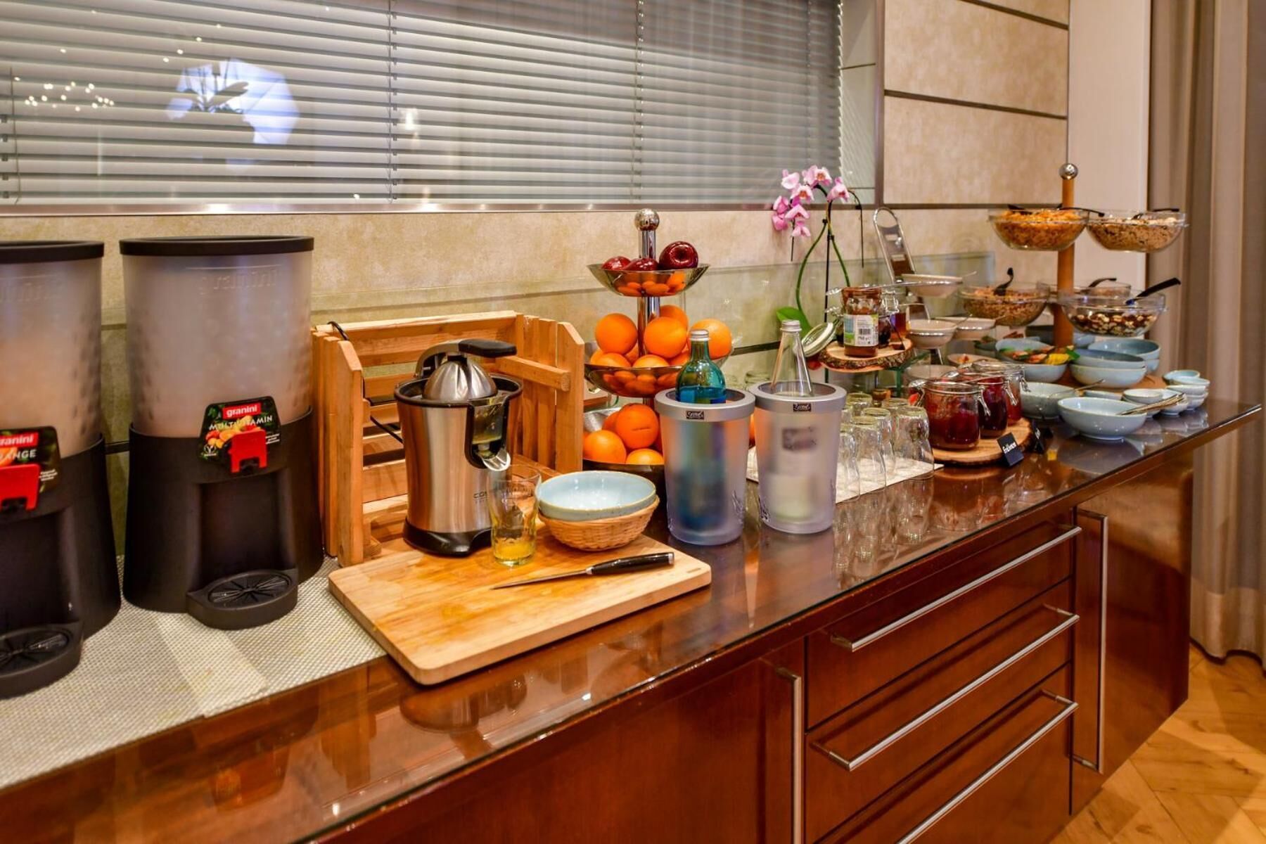 A buffet setup with various food items, a coffee station, and a fruit bowl.