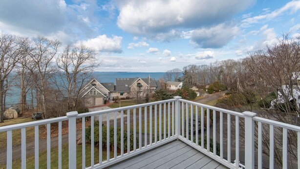 A residential area with houses, a deck, and a view of the water.