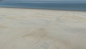 A beach with a clear sky and calm sea.