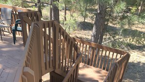 Eine Holztreppe mit Geländer, die zu einer Terrasse führt.