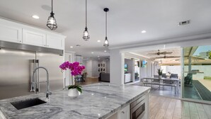 A modern kitchen with a marble countertop, stainless steel appliances, and pendant lighting. - PARADISE IN ARCADIA NEAR SCOTTSDALE 5BED/4BATH + HEATED POOL (Phoenix)