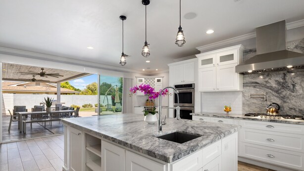 A modern kitchen with white cabinetry, a marble island, and pendant lighting. - PARADISE IN ARCADIA NEAR SCOTTSDALE 5BED/4BATH + HEATED POOL (Phoenix)