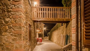 A narrow stone pathway leading to a wooden balcony with a railing. - Borgo dei Gigli (Lamporecchio)