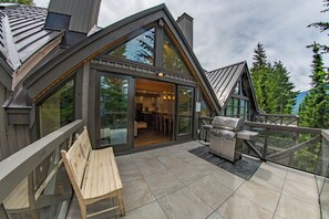 A modern house with a large deck, a wooden bench, and a barbecue grill. - Pinnacle Ridge 36 - Ski in Ski out, Private Hot Tub, Wood Fireplace (Whistler)