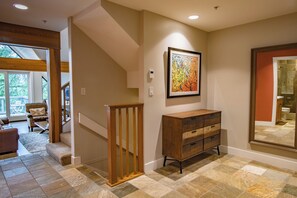 A staircase with a wooden railing, a wooden dresser, and a framed artwork on the wall. - Pinnacle Ridge 36 - Ski in Ski out, Private Hot Tub, Wood Fireplace (Whistler)