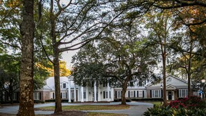 A large, white building with a symmetrical facade, multiple windows, and a central entrance. - Penny-Wise Paradise In Pawleys Island (Pawleys Island)