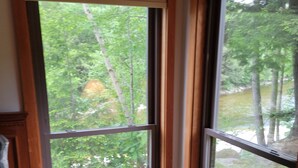 A room with a large window offering a view of a wooded area. - Riverfront, Vacation! Spacious, Bright, Clean! 3 Br/2 Ba
WEEKEND SHUTTLE TO LOON (Lincoln)