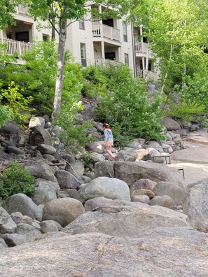 A rocky outdoor area with large boulders and trees, and a building with balconies in the background. - Riverfront, Vacation! Spacious, Bright, Clean! 3 Br/2 Ba
WEEKEND SHUTTLE TO LOON (Lincoln)